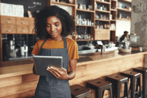 Na imagem, uma jovem pequena empresária, lê em seu tablet a notícia divulgada pela Dr. Fiscal: Receita envia termos de exclusão à devedores do simples nacional
